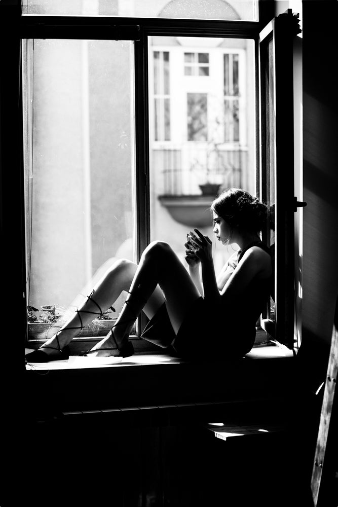 Glass picture Sitting woman on the windowsill